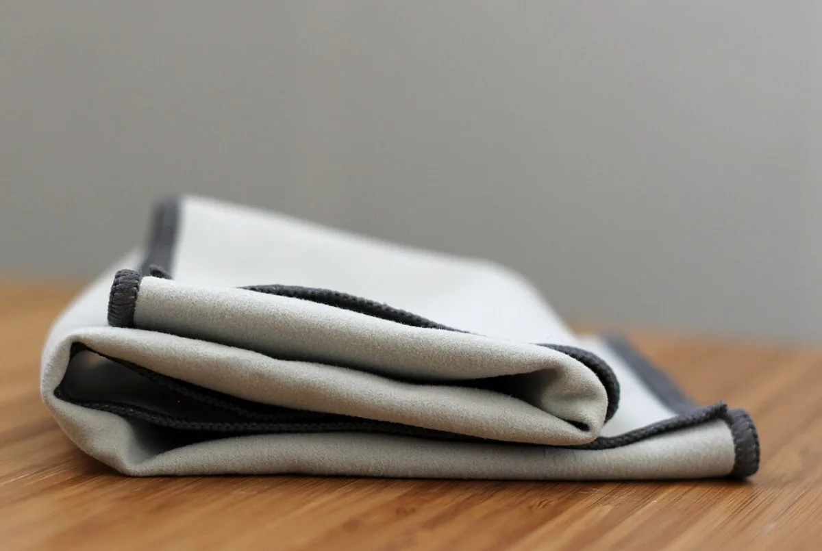 Opgevouwen microvezeldoek op een houten tafelblad